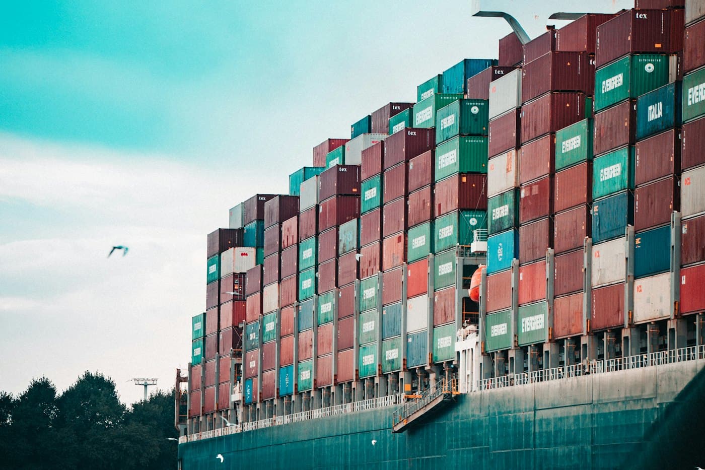 A cargo ship stacked high with shipping containers